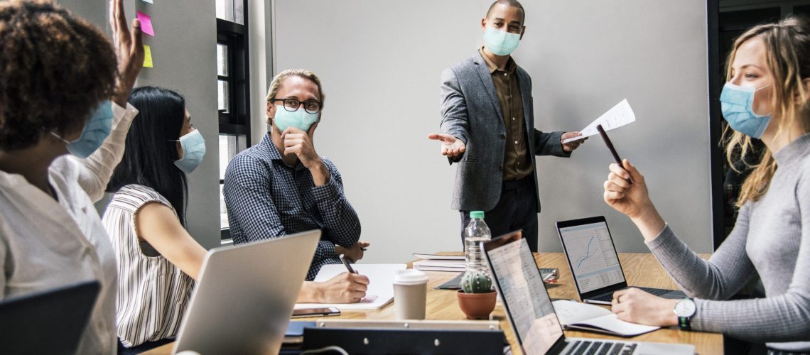 Business people wearing masks in coronavirus meeting, the new normal